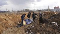 Sejumlah jenazah dimasukkan ke dalam kuburan massal di pinggiran Mariupol, Ukraina, 9 Maret 2022. Warga tidak dapat menguburkan orang mati di antara mereka karena serangan berat oleh pasukan Rusia. (AP Photo/Evgeniy Maloletka)
