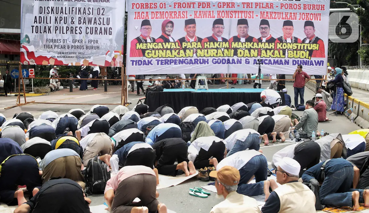 Massa pendemo membuat saf salat dengan beralaskan sajadah hingga terpal. (Liputan6.com/Angga Yuniar)