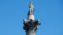 Aktivis lingkungan Greenpeace memasangkan masker pada wajah patung Nelson's Column di Trafalgar Square, pusat kota London, Senin (18/4). Aksi unik itu dilakukan untuk memprotes kualitas polusi udara di kawasan tersebut. (Leon NEAL/AFP)