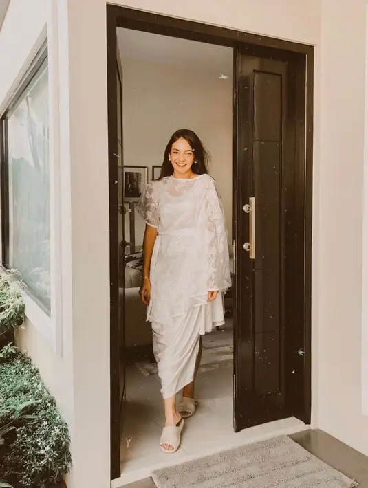 Baju lebaran serba putih dengan detail brukat sebagai outerwear dan inner dress berbahan slik sangat elegan untuk dikenakan oleh kamu, lho. (instagram/enzystoria)