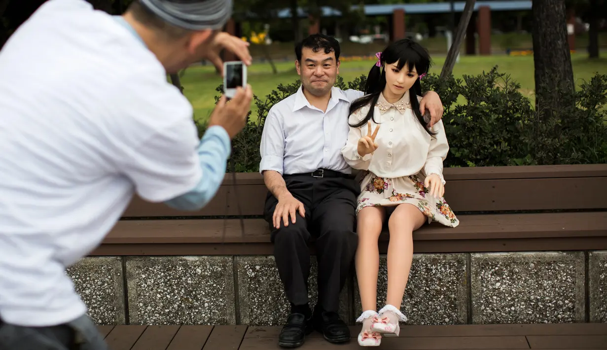 Ahli fisioterapi, Masayuki Ozaki berpose saat difoto bersama boneka seksnya, Mayu di Tokyo, Jepang (9/6). Ozaki menganggap boneka seks bernama Mayu ini layaknya manusia. (AFP photo/Benrouz Mehri)