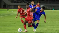 Winger asing Persis Solo, Moussa Sidibe, saat berebut bola dengan bek Arema FC, Johan Ahmat Farizi, dalam duel semifinal Piala Presiden 2024 di Stadion Manahan, Solo, Rabu (31/7/2024). (Bola.com/Radifa Arsa)