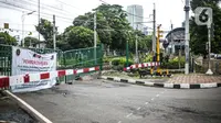 Spanduk pemberitahuan pada perlintasan sebidang yang sudah ditutup di sekitar Stasiun Palmerah, Jakarta, Senin (30/11/2020). Dinas Perhubungan DKI resmi menutup perlintasan sebidang kereta api tersebut terkait adanya program penataan tahap dua di Stasiun Palmerah. (Liputan6.com/Faizal Fanani)