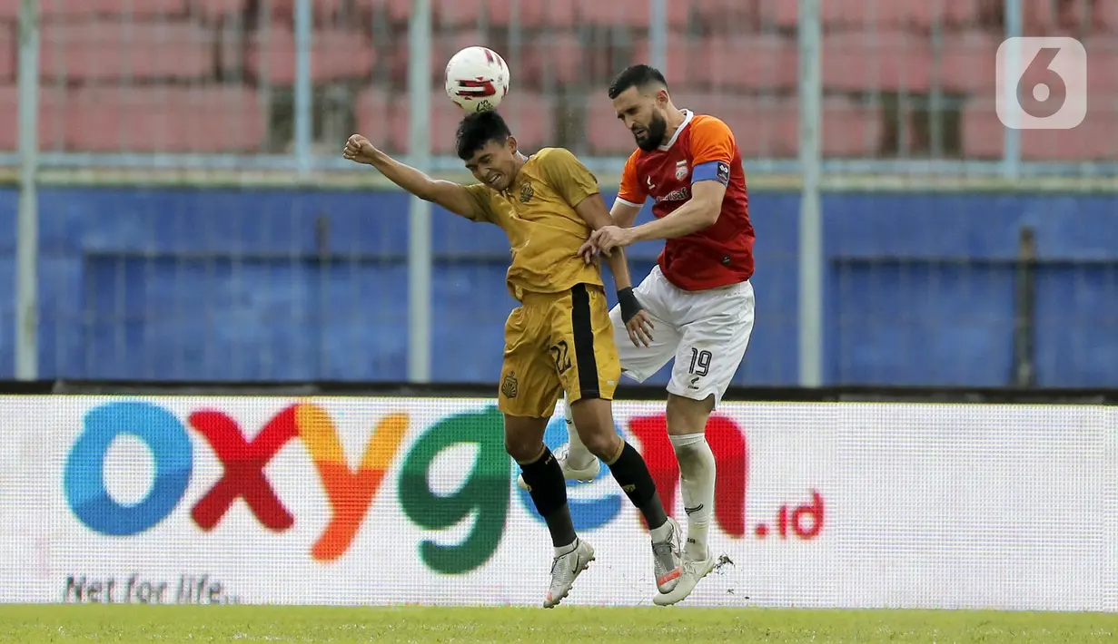 Pemain Borneo FC Samarinda Javlon Guseynov berebut bola dengan pemain Bhayangkara Solo FC Dendy Sulistyawan (kiri) dalam pertandingan babak penyisihan Piala Menpora 2021 di Stadion Kanjuruhan, Malang, Jawa Timur, Senin (22/3/2021). (Bola.com/Arief Bagus)