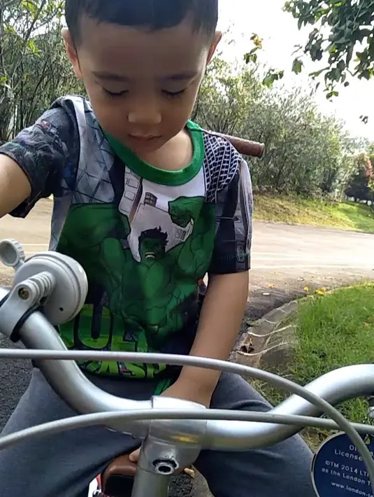 Selanjutnya, Rafathar yang memakai kaus bergambar kartun Hulk ini lucu banget ekspresinya saat belajar mengayuh sepeda di komplek rumahnya.  (Instagram/raffinagita1717)