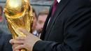 Presiden Rusia Vladimir Putin membawa trofi Piala Dunia FIFA di Stadion Luzhniki, Moskow (9/9). Piala Dunia 2018 akan dimulai di stadion Luzhniki pada 14 Juni 2018. (Mikhail Klimentyev, Sputnik, Kremlin Pool Photo via AP)
