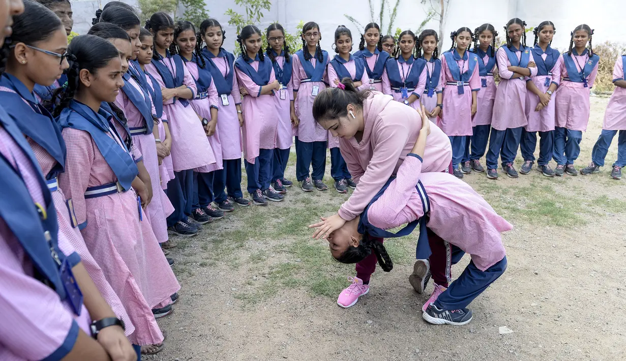 Juara karate internasional Muslim India, Syeda Falak menunjukkan teknik bela diri kepada seorang siswi di Telangana Minorities Residential Girls School di Hyderabad, India (17/6). (AFP Photo/Noah Seelam)
