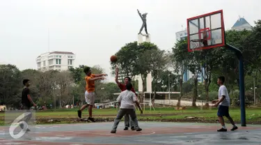 Sejumlah pelajar bermain basket di Kawasan Lapangan Banteng, Jakarta, Senin (29/8). Pemprov DKI Jakarta berencana melakukan desain ulang Lapangan Banteng, sehingga Monumen Pembebasan Irian Barat bisa lebih terlihat. (Liputan6.com/Helmi Fithriansyah)
