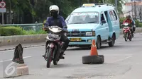 Kendaraan menghindari penanda lubang di Jalan Otista Raya, Jakarta, Rabu (22/2). Kondisi tersebut berbahaya bagi pengguna jalan, khususnya pengendara sepeda motor yang melintas saat malam hari. (Liputan6.com/Immanuel Antonius)