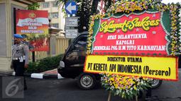 Petugas piket mengecek karangan bunga ucapan selamat atas dilantiknya Komjen Pol Tito Karnavian, Mabes Polri, Jakarta, Rabu (13/7). Tito Karnavian akan dilantik menjadi Kapolri di Istana Negara oleh Presiden Jokowi. (Liputan6.com/Helmi Fithriansyah)