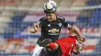 Bek Manchester United, Harry Maguire, duel udara dengan pemain Luton Town, Danny Hylton, pada Piala Liga Inggris di Stadion Kenilworth Road, Rabu (23/9/2020). Setan Merah menang dengan skor 3-0. (Nick Potts/Pool via AP)