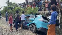 Taksi Green SM yang tertemper oleh KRL di perlintasan sebidang di jalan Ampera, Kota Bekasi, jadi tontonan warga sekitar. (Foto: Liputan6.com/Rifqy Alief Abiyya).