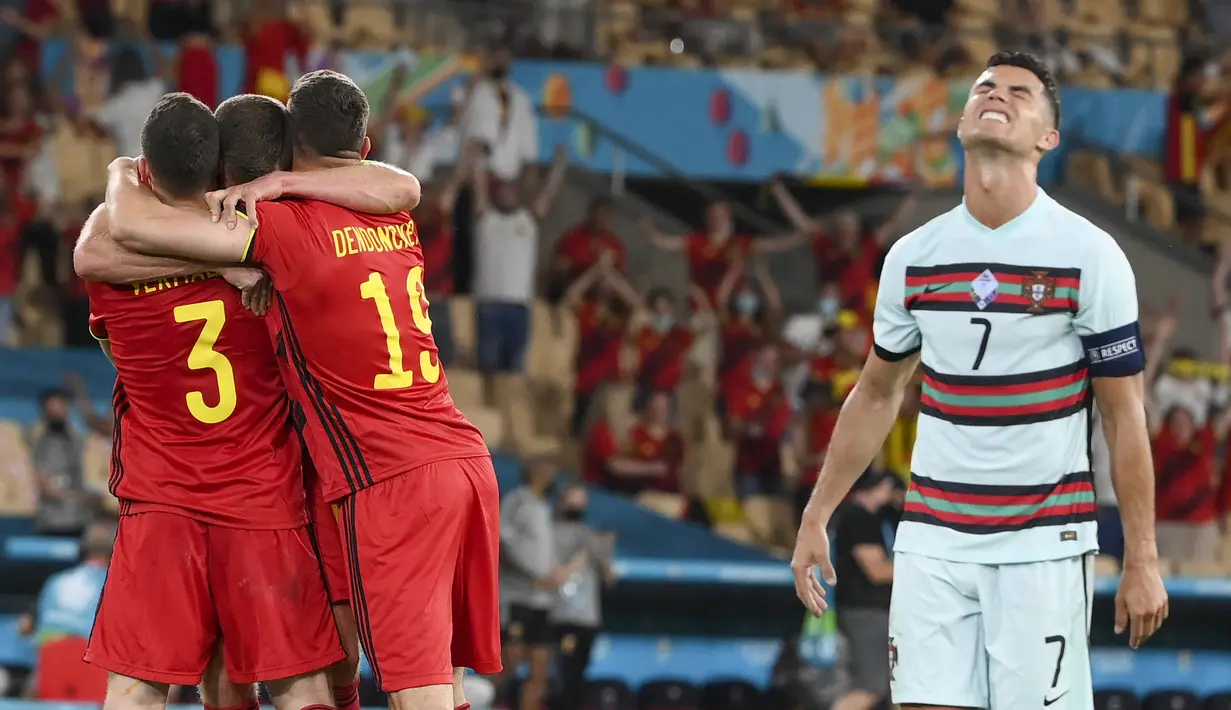 Penyerang timnas Portugal, Cristiano Ronaldo bereaksi ketika para pemain Belgia merayakan kemenangan setelah babak 16 besar Euro 2020 di Estadio La Cartuja, Sevilla, Spanyol, Senin (28/6/2021) dini hari WIB. Belgia mendepak juara bertahan Portugal berkat kemenangan 1-0 (Lluis Gene/Pool Photo via AP)