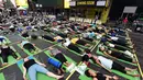 Sejumlah orang melakukan gerakan yoga saat matahari mencapai titik balik di musim panas (summer solstice) di kawasan Times Square, New York, Kamis (21/6). Ribuan orang berkumpul untuk merayakan titik balik matahari di musim panas. (TIMOTHY A. CLARY/AFP)