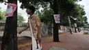 Pelajar melintasi pepohonan yang dipenuhi alat peraga kampanye (APK) calon anggota legislatif (caleg) di Jakarta, Rabu (20/3). Pemasangan APK tersebut melanggar aturan PKPU Nomor 23 Pasal 31 Tentang Bahan Kampanye. (merdeka.com/Iqbal Nugroho)