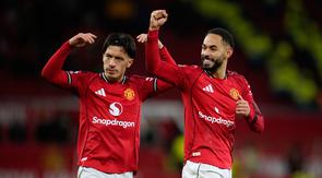 Lisandro Martinez (kiri) dan rekan setimnya, Matheus Cunha, memberikan apresiasi kepada suporter MU selepas duel melawan Newcastle United dalam lanjutan Liga Inggris 2025/2026 di Old Trafford, Sabtu (27/12/2025) dini hari WIB. (AP Photo/Dave Thompson)