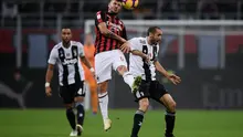 Penyerang muda AC Milan, Cutrone saat melakukan duel udara dengan Chiellini pada lanjutan laga serie a yang berlangsung di stadion San Siro, Milan (12/11). AC Milan kalah 0-2. (AFP/Marco Bertorello)