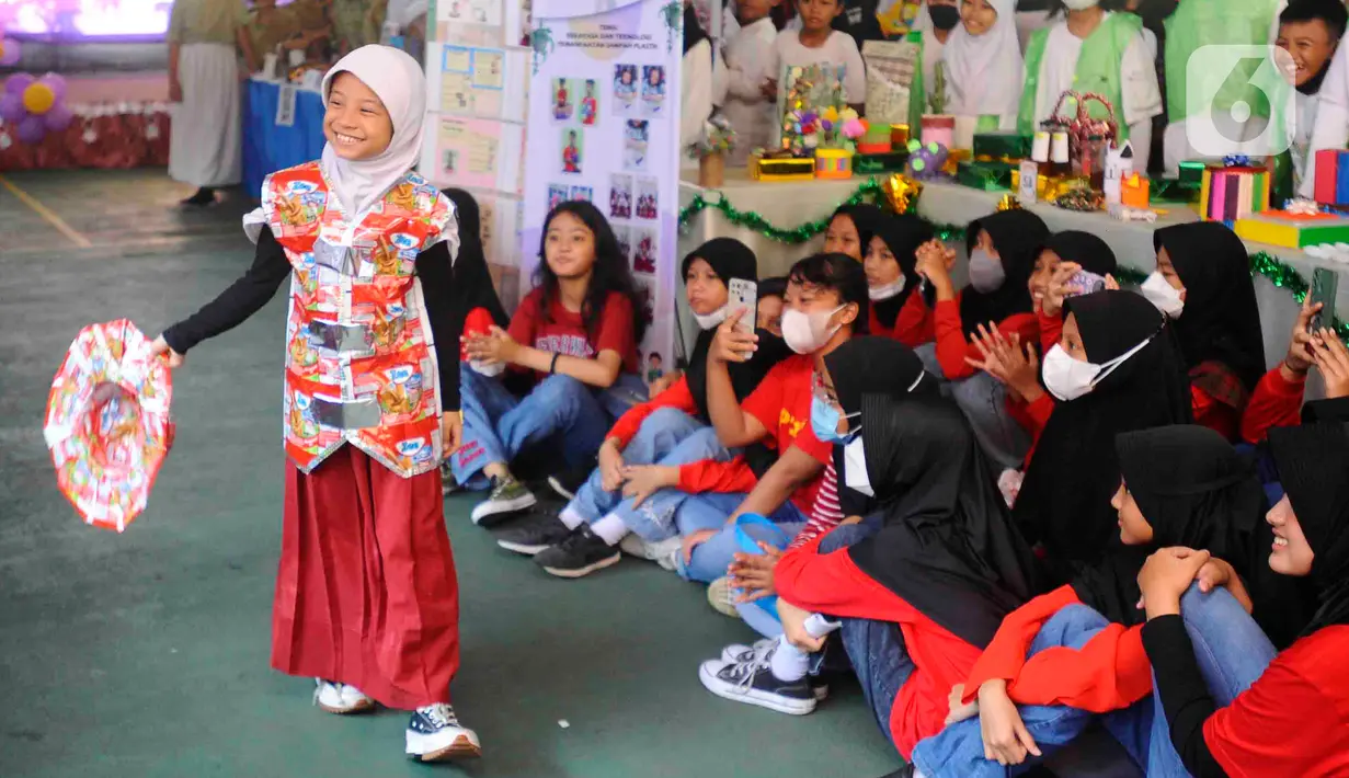 Murid sekolah dasar membawakan pakaian dari daur ulang limbah plastik hasil karya mereka sendiri saat kegiatan fashion show di SDN Anyelir 1, Depok, Jawa Barat, Kamis (15/6/2023). (merdeka.com/Arie Basuki)
