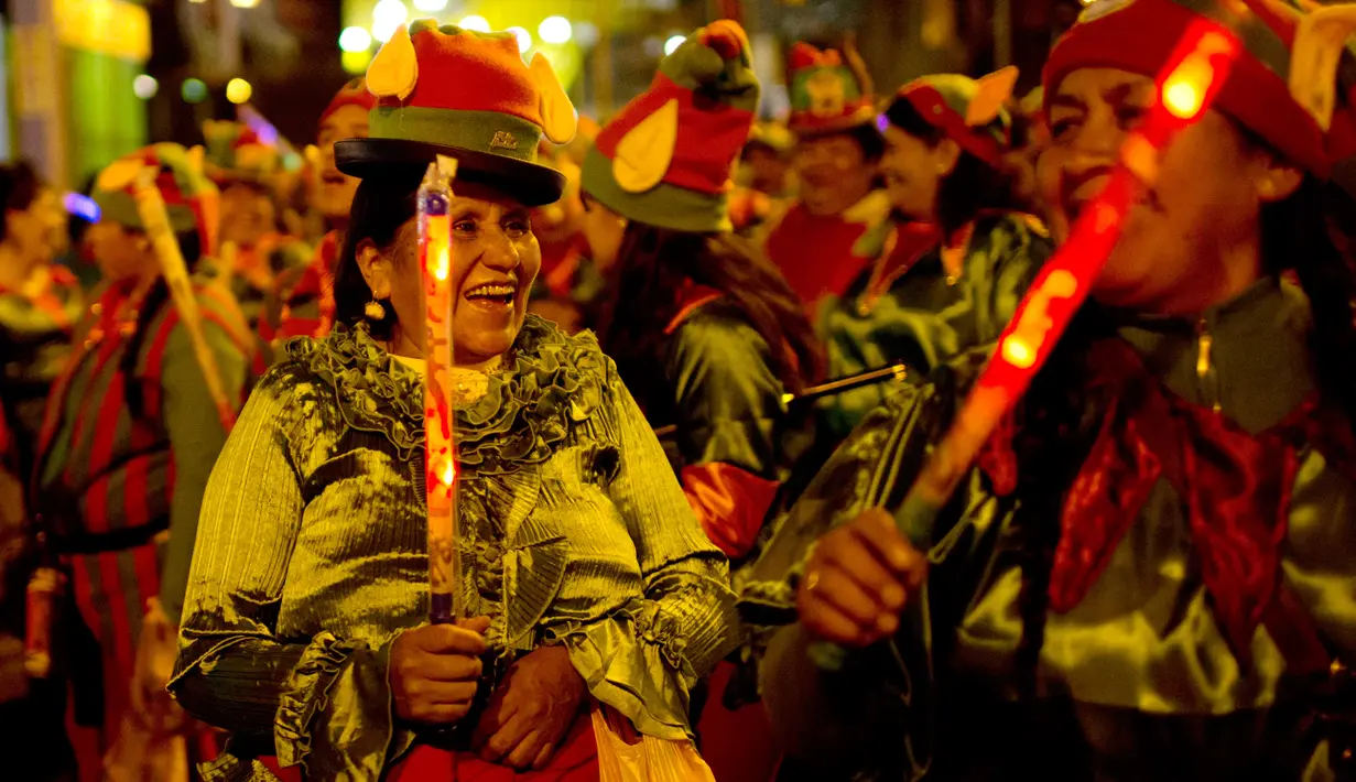 Sejumlah wanita mengenakan kostum elf menari saat parade Natal tahunan di La Paz, Bolivia (24/11). Pawai ini diselenggarakan oleh pedagang Pekan Raya Natal tahunan. (AP Photo/Juan Karita)