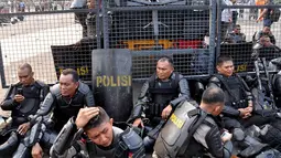 Ratusan polisi yang menjaga aksi demo ribuan pendukung Prabowo beristirahat melepas lelah, Jakarta, Kamis (21/8/14). (Liputan6.com/Miftahul Hayat)