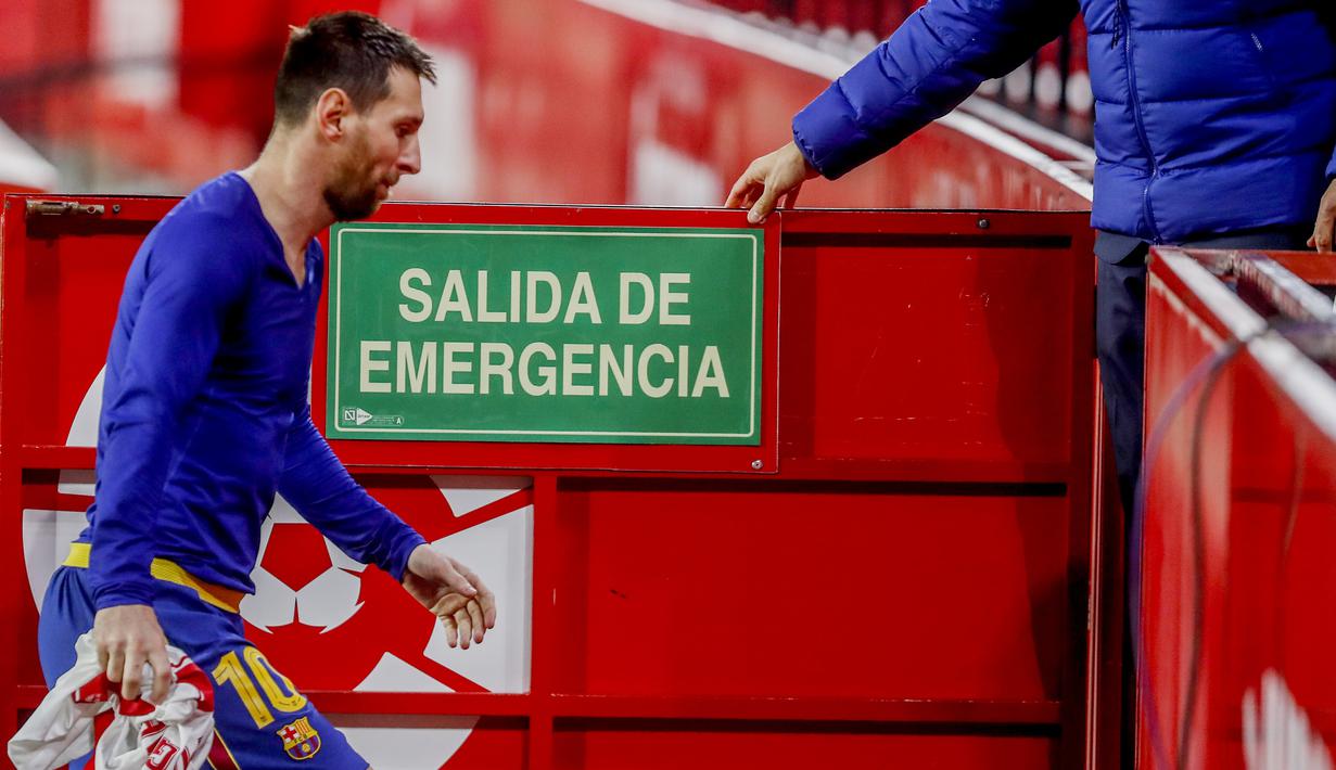 Striker Barcelona, Lionel Messi, meninggalkan lapangan usai ditaklukkan Sevilla pada laga leg pertama semifinal Copa del Rey di Estadio Ramon Sanchez Pizjuan, Kamis (11/2/2021). Barcelona tumbang dengan skor 2-0. (AP/Angel Fernandez)