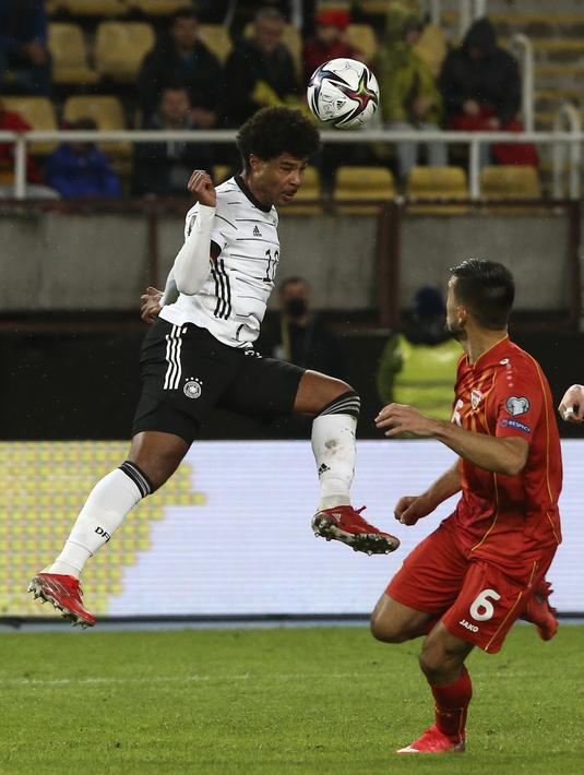 Gelandang Jerman Serge Gnabry menyundul bola dibayangi bek Makedonia Utara Visar Musliu pada lanjutan Kualifikasi Piala Dunia 2022 zona Eropa Grup J di Tose Proeski National Arena, Selasa (12/10/2021) dini hari WIB. Jerman menghajar Makedonia Utara empat gol tanpa balas. (AP Photo/Boris Grdanoski)