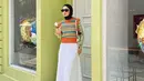 Buat hijabers, bisa tiru gaya Tantri Namirah yang memadukan printed long sleeve top dengan vest motif abstrak nuansa hijau-oranye ini. Lengkapi gaya dengan maxi skirt putih dan sneakers oranye, [Instagram/tantrinamirah]