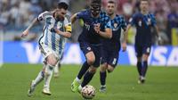 Penyerang Argentina, Lionel Messi berusaha melewati bek Kroasia, Josko Gvardiol selama pertandingan semifinal Piala Dunia 2022 di Stadion Lusail di Lusail, Qatar, Rabu (14/12/2022). Messi menunjukkan skill individunya saat memberikan assist untuk rekannya Alvarez yang menjadi gol. (AP Photo/Manu Fernandez)
