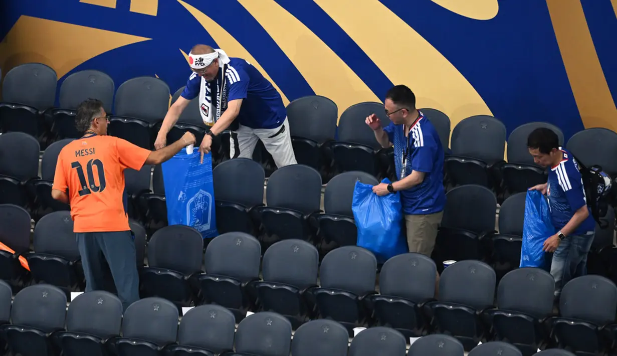 Aksi terpuji suporter Jepang yang selalu membersihkan sampah di tribun seusai pertandingan telah menjadi tradisi ikonik yang mendunia. (AP Photo/Jessica Tobias)