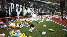 Suporter Persebaya Surabaya, Bonek, melakukan aksi melempar boneka ke pinggir lapangan di Stadion Gelora Bung Tomo, Surabaya, Jumat (29/3/2019). (Bola.com/Aditya Wany)
