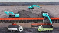 Pekerja menggunakan alat berat untuk memuat batu bara ke truk di Pelabuhan Karya Citra Nusantara (KCN) Marunda, Jakarta, 17 Januari 2022. Indonesia melonggarkan larangan ekspor batu bara. (ADEK BERRY/AFP)