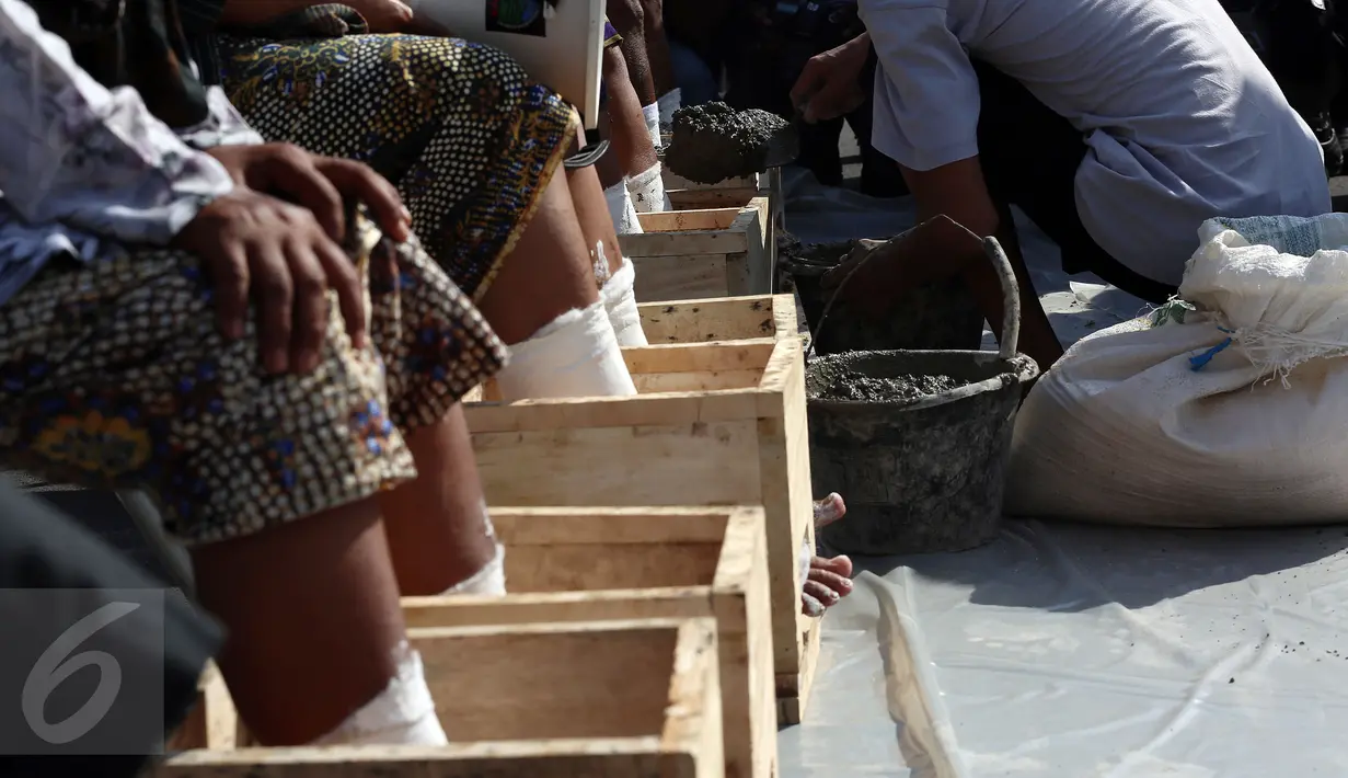 Sejumlah Petani Kendeng menyemen kakinya sebagai bentuk penolakan terhadap Keputusan Gubernur Jawa Tengah Nomor 660.1/6 Tahun 2017, Jakarta, Senin (13/3). (Liputan6.com/Johan Tallo)
