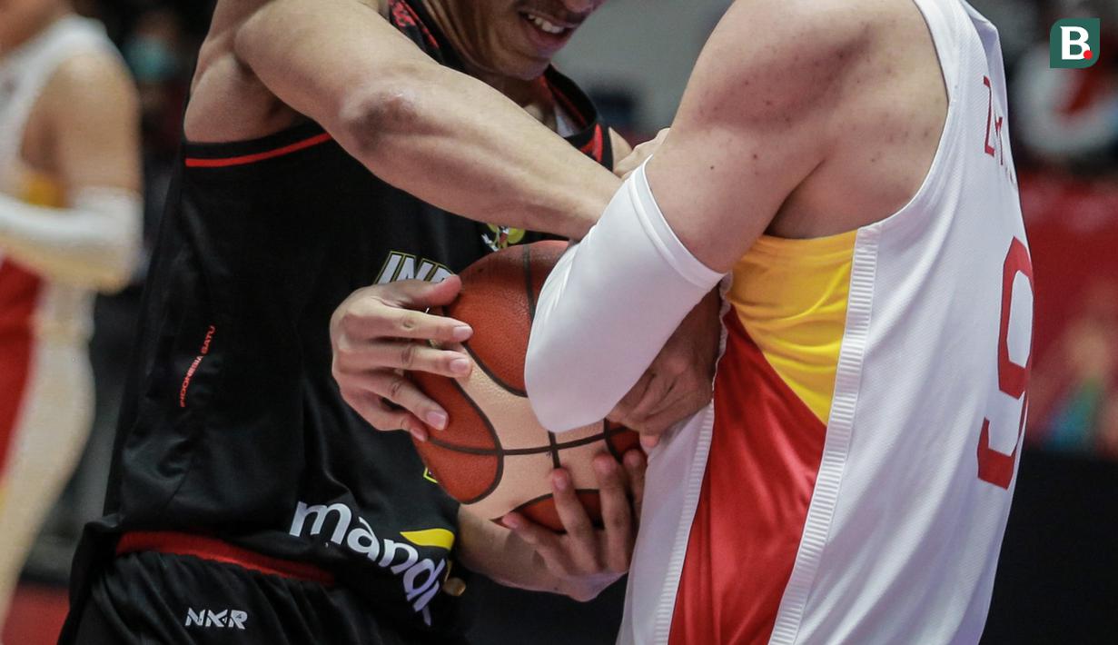 Pemain Timnas Basket Indonesia, Derrick Michael Xzavierro (kiri) berusaha merebut paksa bola dari pemain Timnas Basket China, Zhai Xiaochuan saat laga playoff perempat final FIBA Asia Cup 2022 di Istora Senayan, Jakarta, Senin (18/07/2022). (Bola.com/Bagaskara Lazuardi)