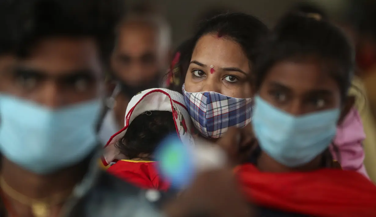 Penumpang yang mengenakan masker menunggu pemeriksaan tes COVID-19 di stasiun kereta jarak jauh di Mumbai, Maharashtra, Minggu (21/3/2021). India sedang menghadapi gelombang baru infeksi Covid-19 dan mencatat rekor lonjakan harian tertinggi dalam hampir empat bulan terakhir. (AP Photo/Rafiq Maqbool)
