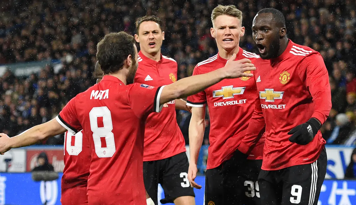 Striker Manchester United, Romelu Lukaku bersama rekan setimnya merayakan gol ke gawang Huddersfield Town dalam pertandingan putaran kelima Piala FA di John Smith's Stadium, Minggu (18/2). Lukaku memborong dua gol kemenangan MU. (Oli SCARFF/AFP)