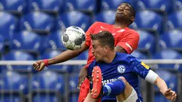 Pemain Augsburg, Felix Uduokha berebut bola dengan Schalke 04, Bastian Oczipka, pada laga Bundesliga di Veltins-Arena, Minggu (24/5/2020). Augsburg menang dengan skor 3-0 atas Schalke 04. (AP/Martin Meissner)