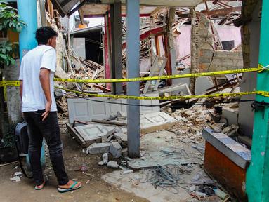 Warga melihat kondisi salah satu rumah yang hancur pasca-ledakan di kawasan permukiman Pondok Cabe Ilir, Pamulang, Tangerang Selatan, Banten, Jumat (12/9/2025). (merdeka.com/Arie Basuki)