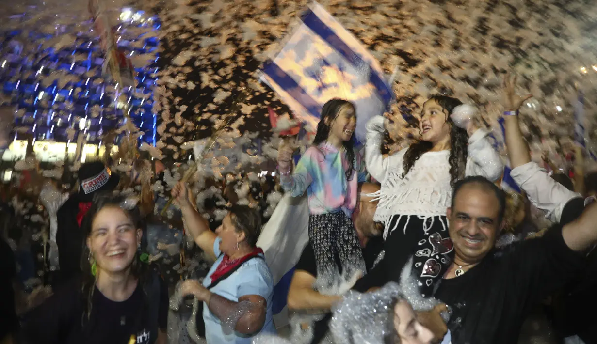 Warga Israel merayakan pelantikan pemerintahan baru di Tel Aviv, Israel, Minggu, 13 Juni 2021. Naftali Bennett, mantan sekutu Benjamin Netanyahu menjadi perdana menteri baru Israel. (AP Photo/Oded Balilty)