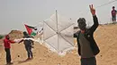 Warga Palestina bersiap menerbangkan layang-layang yang telah diberikan bom molotov di atas pagar perbatasan dengan Israel, di pinggiran timur Kota Gaza (20/4). Unjuk rasa warga Palestina terhadap Isrel memasuki minggu keempat. (AFP Photo/Mohammed Abed)