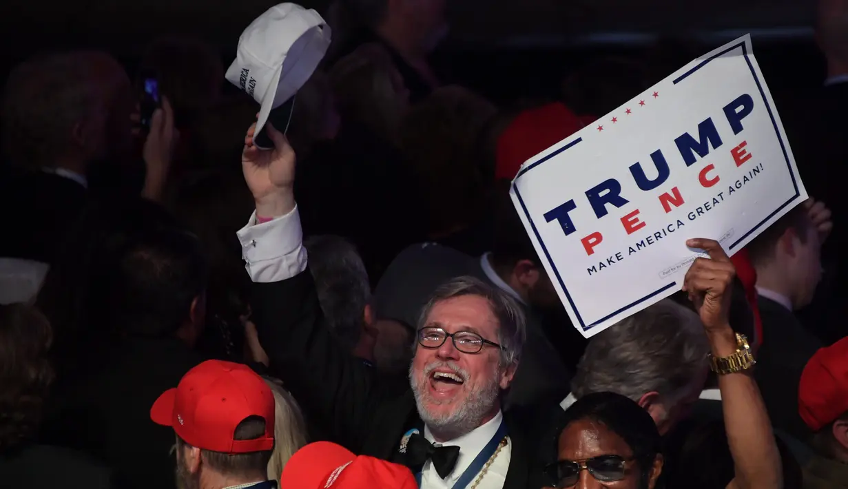 Seorang pendukung mengangkat topinya sat merayakan kemenangan Presiden AS terpilih Donald Trump di New York Hilton Midtown di New York, AS, (9/11). (AFP PHOTO / JIM WATSON)