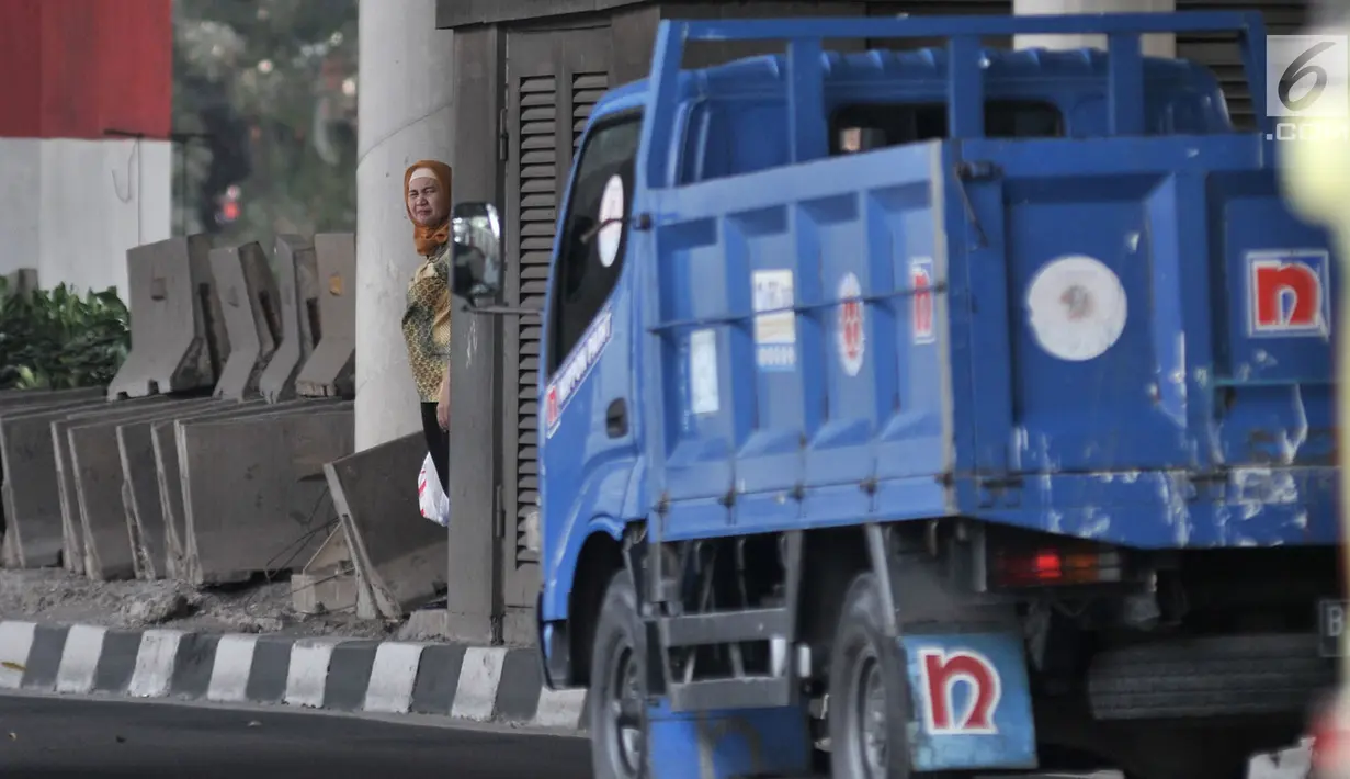 Seorang pejalan kaki berdiri di trotoar saat hendak menyeberangi jalan di kawasan Prumpung, Jakarta, Selasa (18/9).(merdeka.com/ Iqbal S. Nugroho)