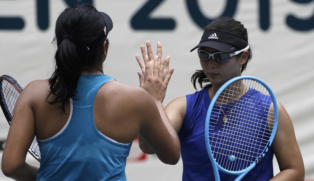 Petenis Indonesia, Beatrice Gumulya dan Jessy Rompies, merayakan kemenangan di laga perempat final BNI Tennis Open 2019 di lapangan tenis The Sultan Hotel, Jakarta, Rabu (20/11). Ajang ini diharapkan menjadi wadah persiapan atlet menjelang SEA Games 2019. (Bola.com/Yoppy Renato)