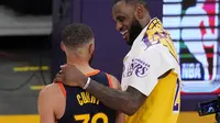 Pebasket Los Angeles Lakers, LeBron James (kanan) merangkul pemain Golden State Warriors, Stephen Curry, setelah berhadapan di play-in-tournament NBA. (AP/Mark J. Terrill).
