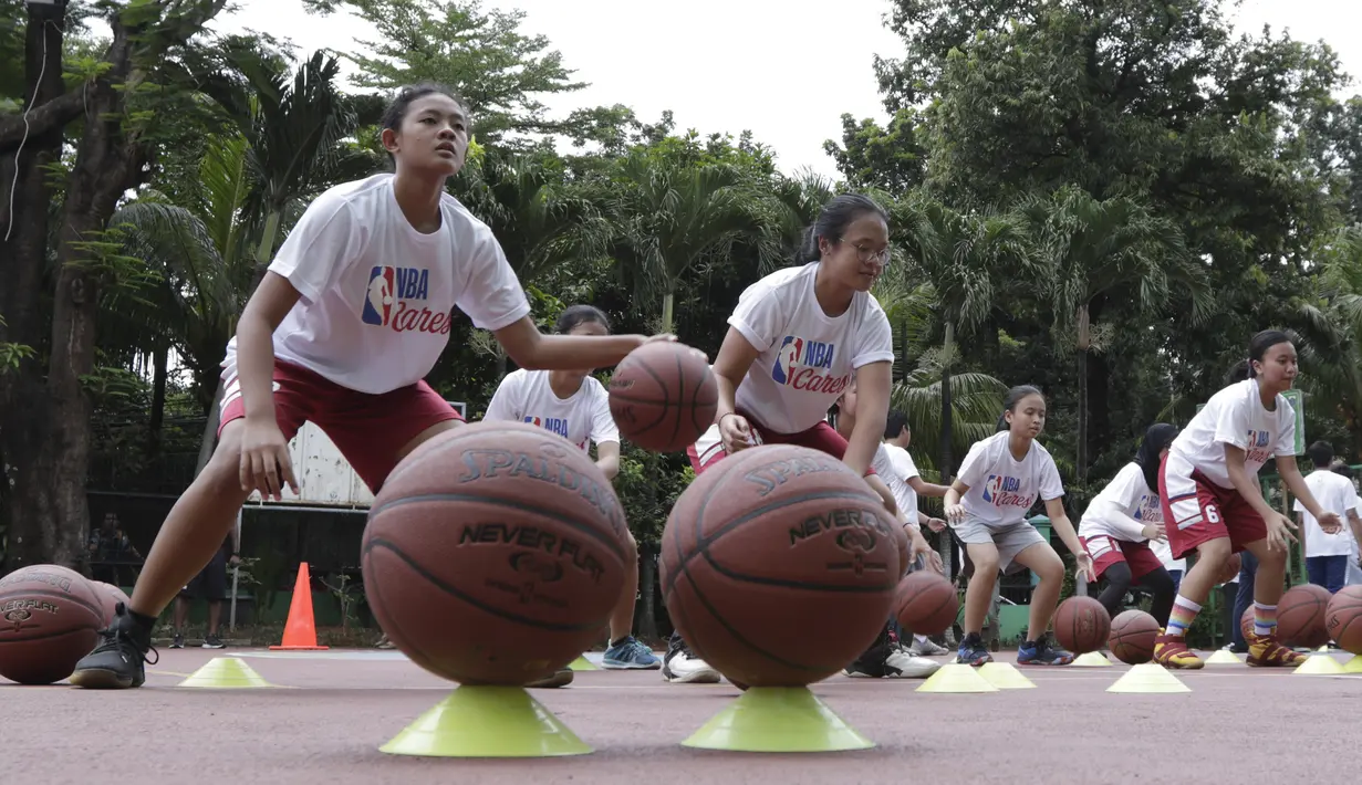 Sejumlah siswa mengikuti pelatihan oleh Legenda NBA, Jason Richardson, di SMA 82 Jakarta, Kamis (28/3). Kunjungan peraih dua gelar juara kontes slamdunk NBA tersebut merupakan bagian dari rangkaian program Jr NBA. (Bola.com/M Iqbal Ichsan)