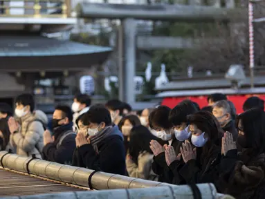 Para jamaah berdoa di kuil Yushima Tenmangu di Tokyo pada Hari Tahun Baru, Jumat (1/1/2020). Warga di Tokyo ramai-ramai mengunjungi Kuil Yushima Tenmangu untuk berdoa dengan menulis harapan di papan Ema. (AP Photo/Hiro Komae)