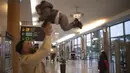 Seorang pria bermain dengan anak ketika menunggu untuk berangkat di terminal bandara Rabat, Maroko, Senin (29/11/2021). Maroko menangguhkan semua penerbangan internasional mulai Senin tengah malam selama dua minggu karena kekhawatiran pada varian baru Covid-19 Omicron. (AP Photo/Mosa'ab Elshamy)