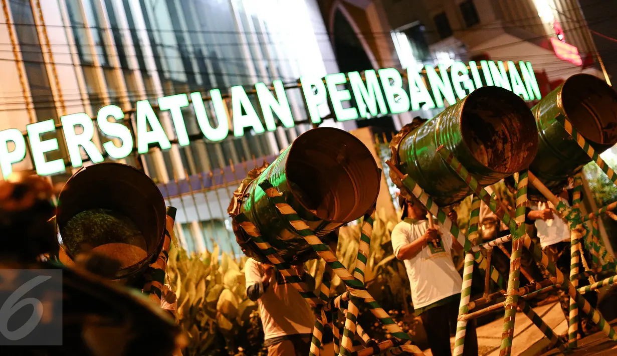 Sejumlah masyarakat memukul bedug saat malam takbiran di depan Kantor DPP PPP, Jakarta, Selasa (5/7). Pemerintah melalui Kemenag telah menetapkan 1 Syawal 1437 H jatuh pada tanggal 6 Juli 2016. (Liputan6.com/Faizal Fanani)