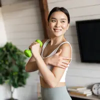 Seorang perempuan sedang berolahraga dengan mengangkat beban (Foto Dok: Freepik/benzoix).