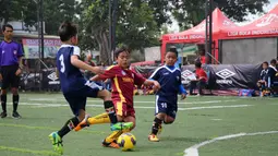 Seorang anak berusaha melewati lawannya saat berlaga pada Liga Bola Indonesia. Persaingan tidak kalah sengit untuk kategori U-9, sebanyak 12 tim yang bertarung dalam kategori ini. (Bola.com/Vitalis Yogi Trisna)