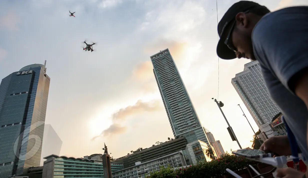 Seorang pilot drone saat menerbangkan drone di Bundaran HI, Jakarta, Kamis(28/5/2015). Penggunaan pesawat terbang tanpa awak atau yang sering disebut sebagai drone mulai dilarang di beberapa negara. (Liputan6.com/Faizal Fanani)
